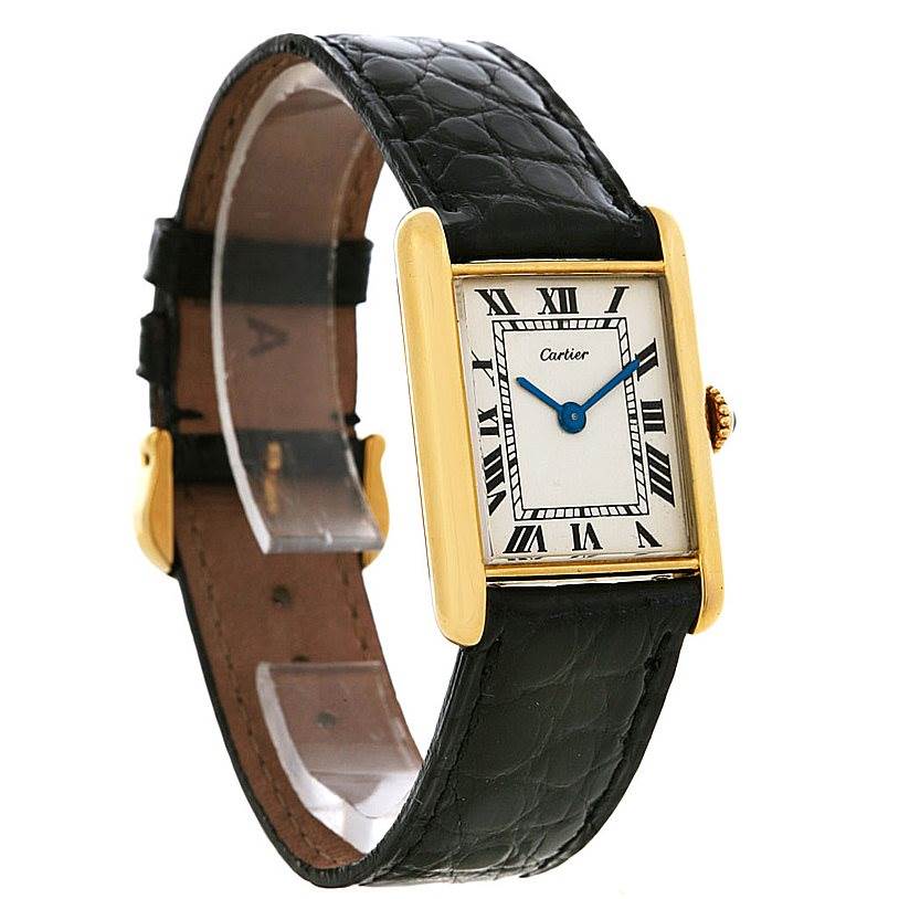 The image shows a Cartier Tank Classic Yellow Gold White Dial Yellow Gold White Dial watch with a gold case, Roman numeral dial, and black leather strap at an angled view.