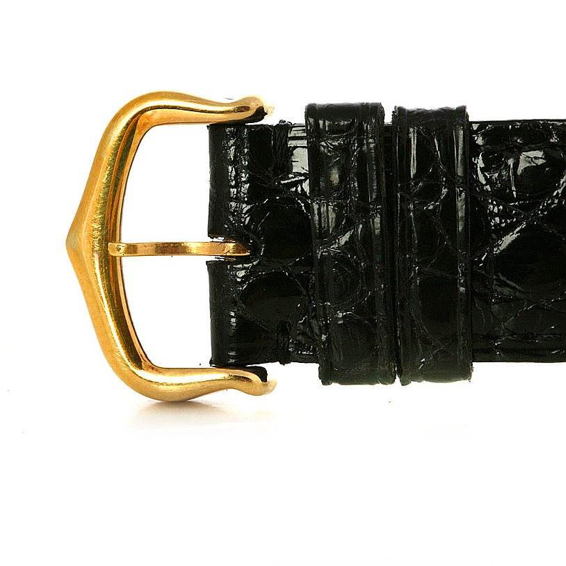 The image shows a close-up of the gold-tone buckle and black leather strap of a Cartier Tank Classic Yellow Gold White Dial Yellow Gold White Dial watch.