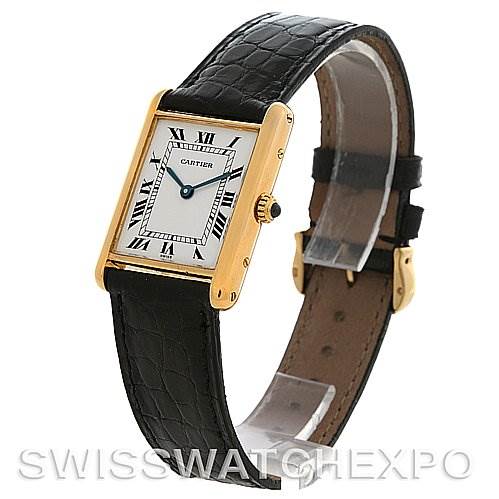 The image shows a Cartier Tank Classic Yellow Gold White Dial Yellow Gold White Dial watch from an angled view, highlighting its rectangular face, Roman numerals, and black leather strap.