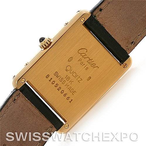 This image shows the back of a Cartier Tank Classic Yellow Gold White Dial Yellow Gold White Dial watch, highlighting the case, inscriptions, and part of the leather strap.