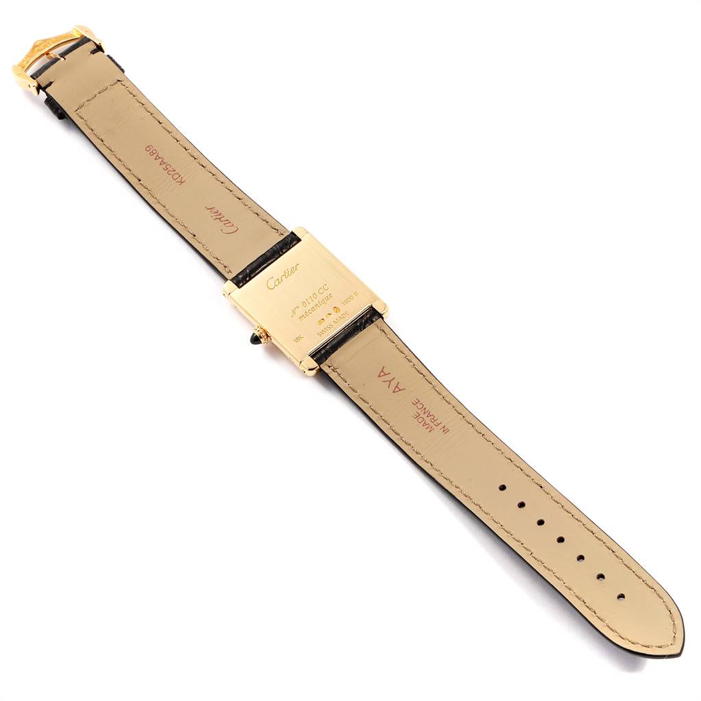 The image shows the underside of a Cartier Tank Classic Men
s Yellow Gold Silver Dial Men
s Yellow Gold Silver Dial watch, highlighting its leather strap and case back.