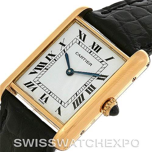 The Cartier Tank Classic Yellow Gold White Dial Yellow Gold White Dial watch is shown at an angle displaying its gold rectangular case, white dial, Roman numerals, and black leather strap.