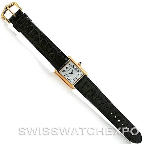 This image shows a top-down view of a Cartier Tank Classic Yellow Gold White Dial Yellow Gold White Dial watch with a gold case and black leather strap.