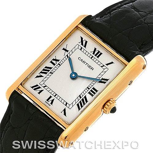 The image shows a Cartier Tank Classic Yellow Gold White Dial Yellow Gold White Dial watch from an oblique angle, highlighting its rectangular dial, Roman numerals, and leather strap.