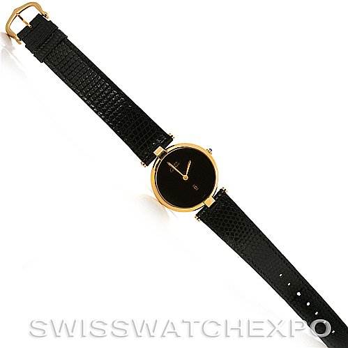 The image shows a top-down view of a Cartier Tank Classic Yellow Gold Black Dial Yellow Gold Black Dial watch with a black strap and a gold case.