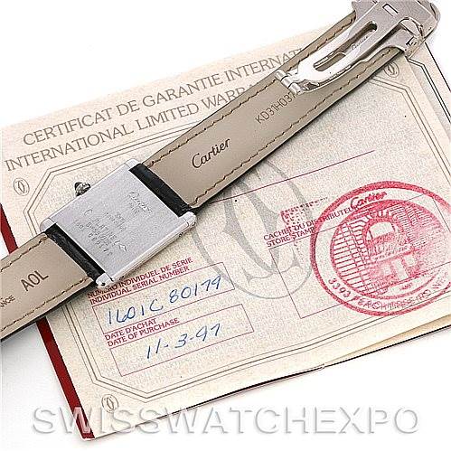 The image shows the backside of the strap and clasp of a Cartier Tank Classic Men's Platinum Silver Dial Men's Platinum Silver Dial watch, placed over its certificate of guarantee.