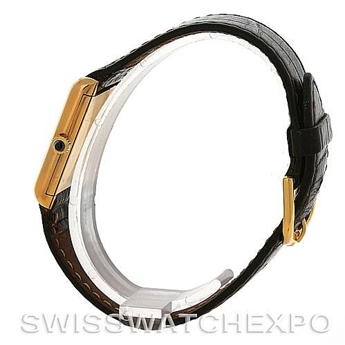 The image shows a Cartier Tank Classic Yellow Gold White Dial Yellow Gold White Dial model from a side angle, highlighting its gold case, blue cabochon crown, and leather strap.