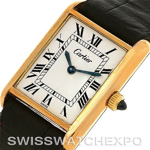 The Cartier Tank Classic Yellow Gold White Dial Yellow Gold White Dial watch is shown from an angled view, highlighting its rectangular face, Roman numerals, and leather strap.