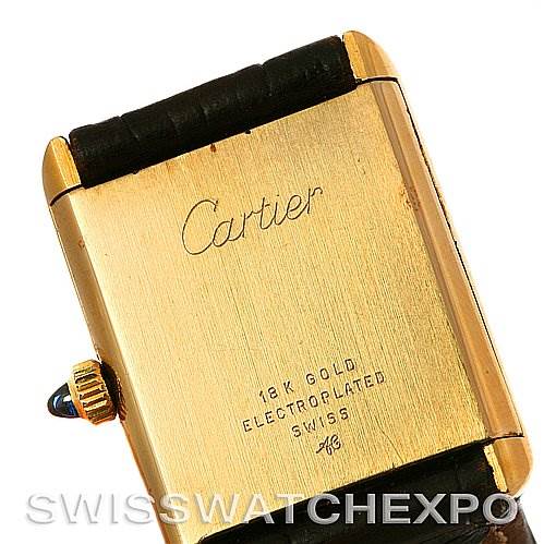 This image shows the back case of the Cartier Tank Classic Yellow Gold White Dial Yellow Gold White Dial watch, highlighting its gold plating and inscriptions.