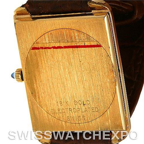 This image shows the back view of a Cartier Tank Classic Men's Yellow Gold White Dial Men's Yellow Gold White Dial watch, focusing on its gold electroplated case and leather strap.