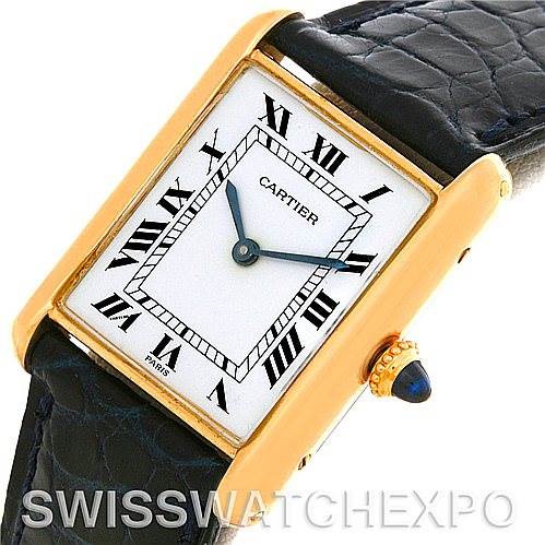 The image shows a Cartier Tank Classic Yellow Gold White Dial Yellow Gold White Dial watch at an angle displaying its face, gold case, black leather strap, and crown with a blue cabochon.