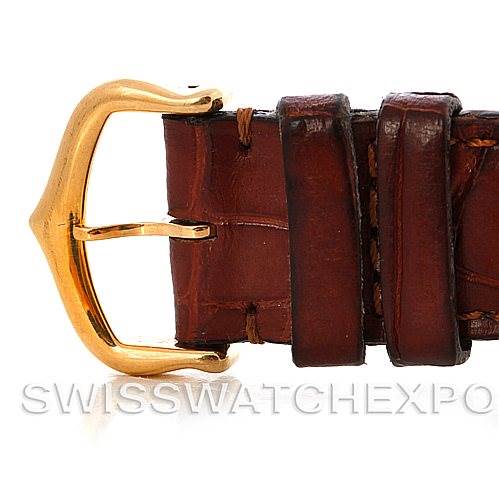 The image shows a close-up view of the brown leather strap and gold buckle of a Cartier Tank Classic Men's Yellow Gold White Dial Men's Yellow Gold White Dial watch.