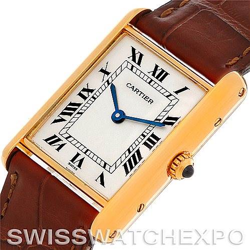 The image shows a close-up of the Cartier Tank Classic Men's Yellow Gold White Dial Men's Yellow Gold White Dial watch face and part of the brown leather strap at a slightly tilted angle.
