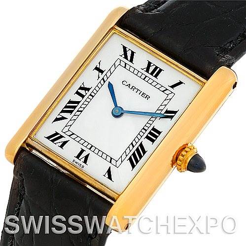 The image shows a Cartier Tank Classic Men's Yellow Gold White Dial Men's Yellow Gold White Dial model watch from an angled top view, highlighting its rectangular dial, blue hands, and black leather strap.