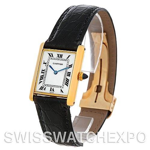 The image shows a Cartier Tank Classic Men's Yellow Gold White Dial Men's Yellow Gold White Dial watch at an angled view, highlighting its rectangular face, gold casing, black leather strap, and blue hands.