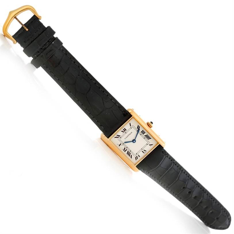 The image shows a Cartier Tank Classic Men's Yellow Gold White Dial Men's Yellow Gold White Dial watch, angled horizontally, displaying its rectangular face and black leather strap.