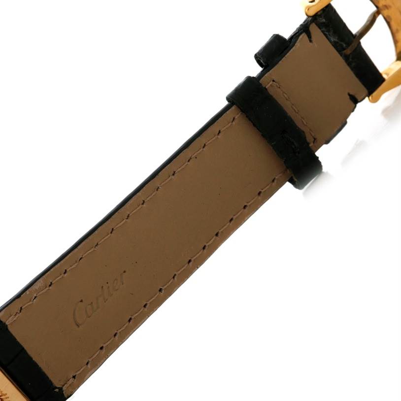 The image displays a close-up of the leather strap of a Cartier Tank Classic Men's Yellow Gold White Dial Men's Yellow Gold White Dial watch, highlighting the stitches and brand imprint.