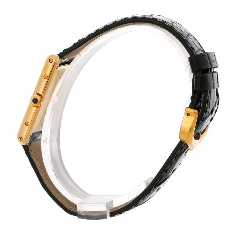 The image shows a side view of the Cartier Tank Classic Men's Yellow Gold White Dial Men's Yellow Gold White Dial watch, highlighting its gold case and black leather strap.