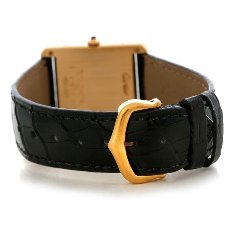 This image shows the back of a Cartier Tank Classic Men's Yellow Gold White Dial Men's Yellow Gold White Dial watch, highlighting its black leather strap and gold buckle.