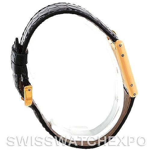 The image shows a side view of the Cartier Tank Classic Men's Yellow Gold White Dial Men's Yellow Gold White Dial, highlighting its black strap and gold watch case.