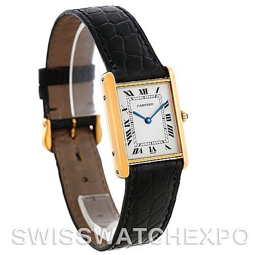 The image shows a Cartier Tank Classic Men's Yellow Gold White Dial Men's Yellow Gold White Dial watch at a three-quarter angle, highlighting its gold rectangular face and black leather strap.