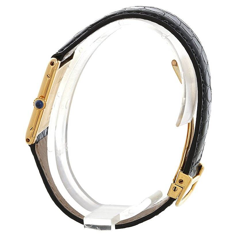 The image shows a side view of the Cartier Tank Classic Men's Yellow Gold White Dial Men's Yellow Gold White Dial watch, highlighting its gold case and black leather strap.