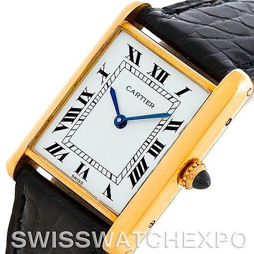 This image shows a Cartier Tank Classic Men
s Yellow Gold Silver Dial Men
s Yellow Gold Silver Dial watch at an angled view, displaying its face, black leather strap, and crown with a gemstone.