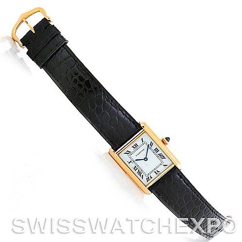 This image shows a Cartier Tank Classic Men
s Yellow Gold Silver Dial Men
s Yellow Gold Silver Dial watch with a black leather strap and gold rectangular case, laid flat from a top-down angle.