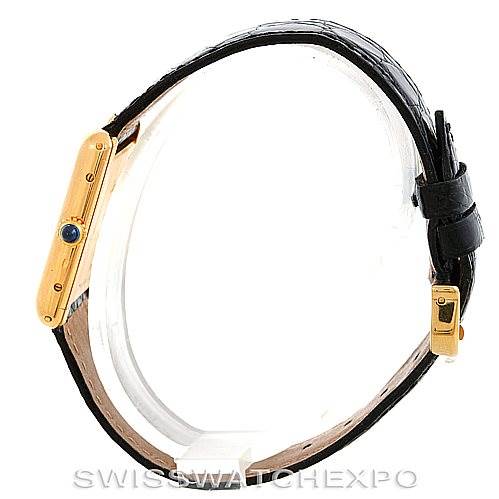 The image shows a side view of the Cartier Tank Classic Men's Yellow Gold White Dial Men's Yellow Gold White Dial watch, highlighting its gold case, crown, and black leather strap.