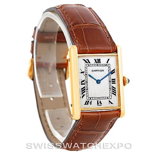 The image shows the Cartier Tank Classic Men's Yellow Gold Silver Dial Men's Yellow Gold Silver Dial watch from an angle displaying the face, crown, and brown leather strap.