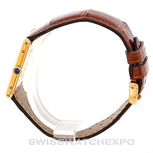 The image shows a side view of the Cartier Tank Classic Men's Yellow Gold Silver Dial Men's Yellow Gold Silver Dial watch with a brown leather strap and a sapphire crown.