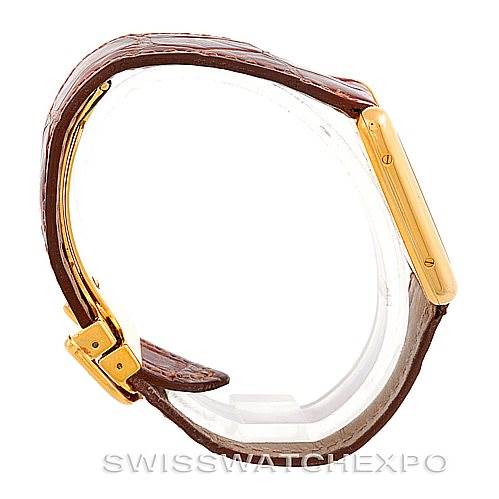 The image shows a side view of the Cartier Tank Classic W002953 Men's Yellow Gold White Dial W002953 Men's Yellow Gold White Dial watch, highlighting its brown leather strap and gold case.