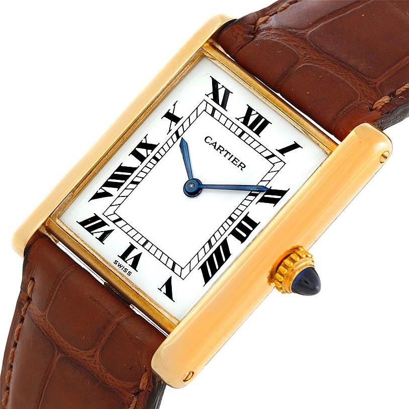 The image shows a Cartier Tank Classic Men
s Yellow Gold White Dial Men
s Yellow Gold White Dial watch angled slightly to display the white dial, Roman numerals, blue hands, gold case, and brown leather strap.