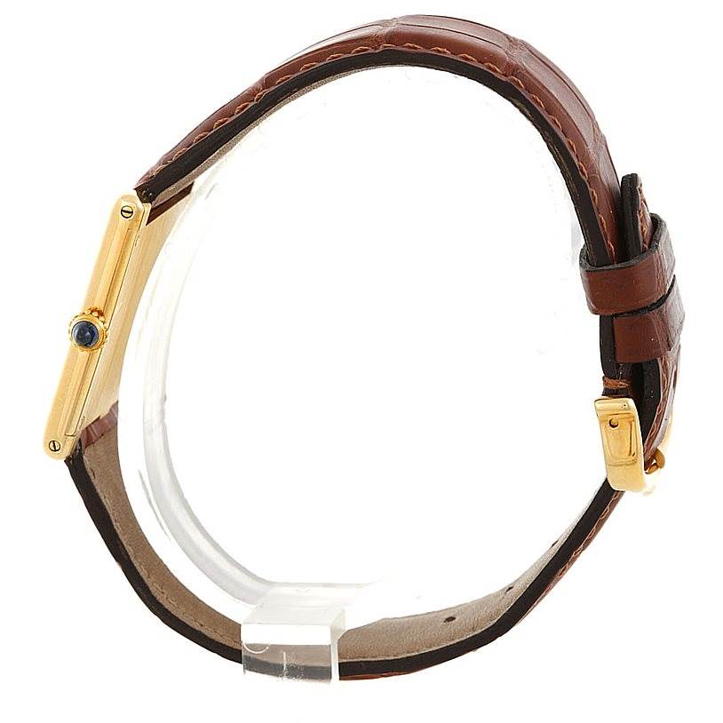 This image shows a Cartier Tank Classic Men
s Yellow Gold White Dial Men
s Yellow Gold White Dial watch in a side profile, highlighting the gold case, crown, and brown leather strap.