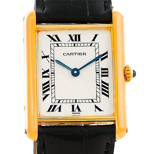 The image shows a front view of a Cartier Tank Classic Men's Yellow Gold Silver Dial Men's Yellow Gold Silver Dial watch, featuring a rectangular gold case, white dial, Roman numerals, and black leather strap.