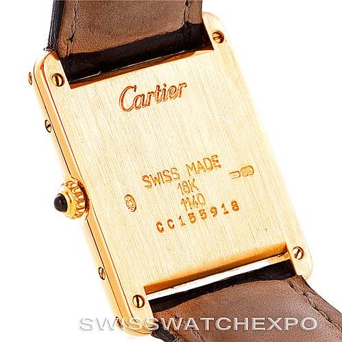 The image shows the back case and part of the strap of a Cartier Tank Classic Men's Yellow Gold Silver Dial Men's Yellow Gold Silver Dial watch in a close-up angle.