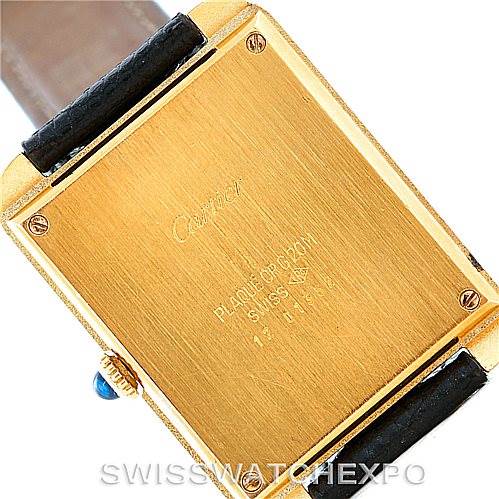The image shows the back of a Cartier Tank Classic Men's Yellow Gold White Dial Men's Yellow Gold White Dial watch, including the case back and parts of the leather strap.