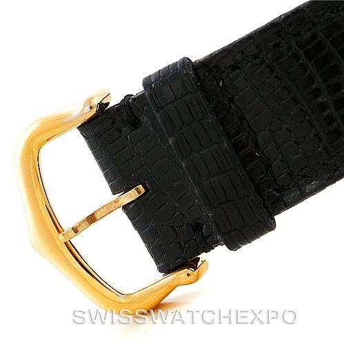 The image shows a close-up view of the black leather strap and gold buckle of a Cartier Tank Classic Men's Yellow Gold White Dial Men's Yellow Gold White Dial watch.