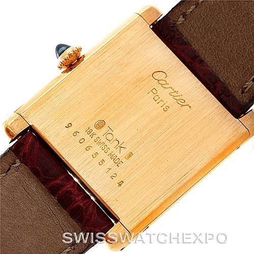 The image shows the back case and part of the leather strap of a Cartier Tank Classic 960655124 Men's Yellow Gold Silver Dial 960655124 Men's Yellow Gold Silver Dial watch, engraved with the brand name and model info.