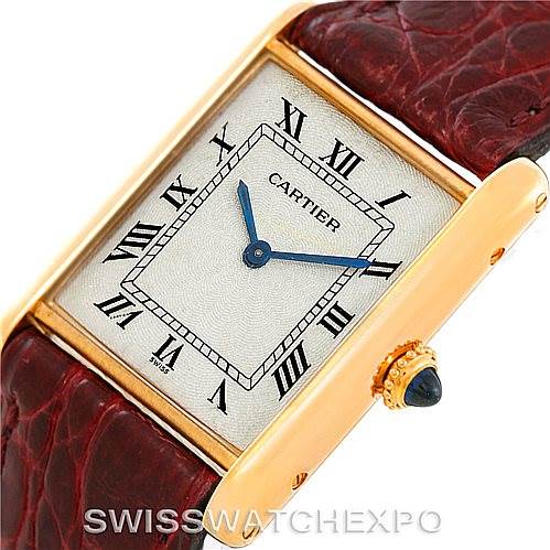 The image shows a close-up of the dial, hands, crown with a blue cabochon bead, and part of the leather strap of a Cartier Tank Classic 960655124 Men's Yellow Gold Silver Dial 960655124 Men's Yellow Gold Silver Dial watch.