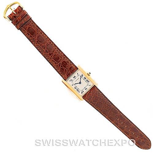 The image shows a Cartier Tank Classic Men's Yellow Gold Silver Dial Men's Yellow Gold Silver Dial watch from a top-down angle, featuring its rectangular face, Roman numeral dial, and brown leather strap.