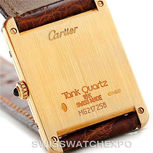 The image shows the back case of the Cartier Tank Classic Men's Yellow Gold Silver Dial Men's Yellow Gold Silver Dial watch, highlighting the "Tank Quartz" engraving and the gold finish.