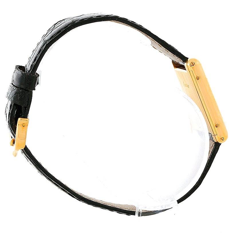 The image shows a side view of a Cartier Tank Classic Men's Yellow Gold White Dial Men's Yellow Gold White Dial watch, focusing on the gold-toned case and the black leather strap.