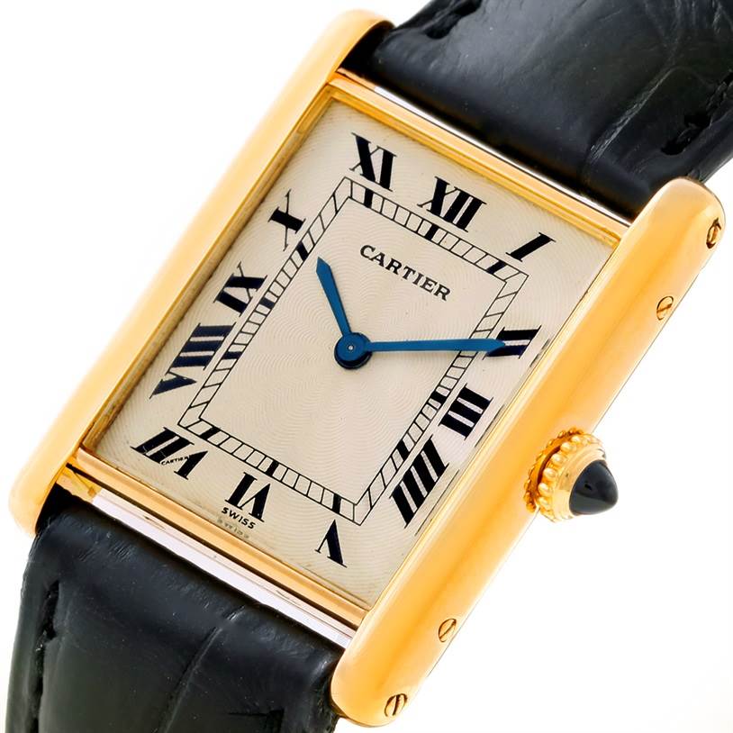 The image shows a close-up view of the Cartier Tank Classic Men's Yellow Gold Beige Dial Men's Yellow Gold Beige Dial watch, featuring its dial, Roman numerals, and crown.