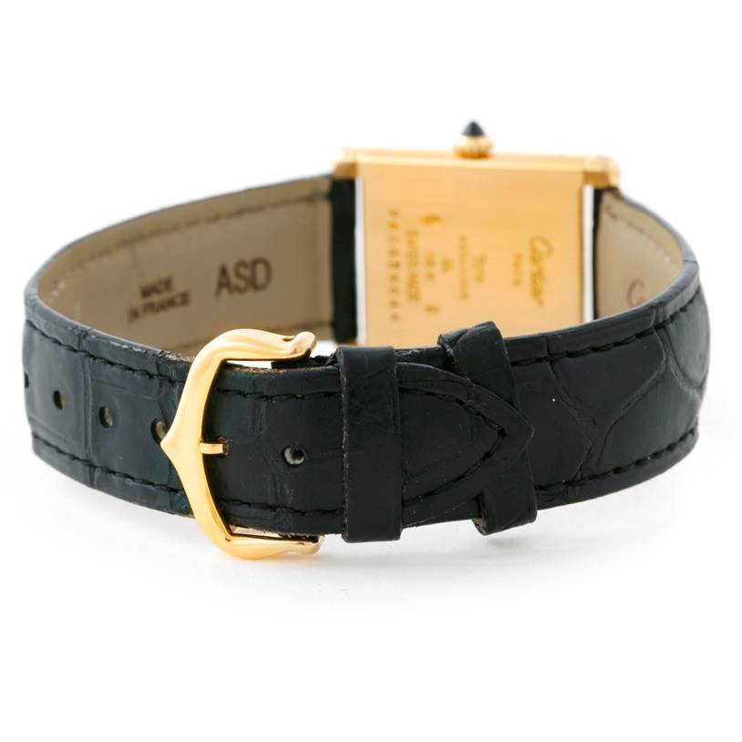 The image shows the back view of the Cartier Tank Classic Men's Yellow Gold Beige Dial Men's Yellow Gold Beige Dial watch, highlighting the gold buckle and black leather strap.