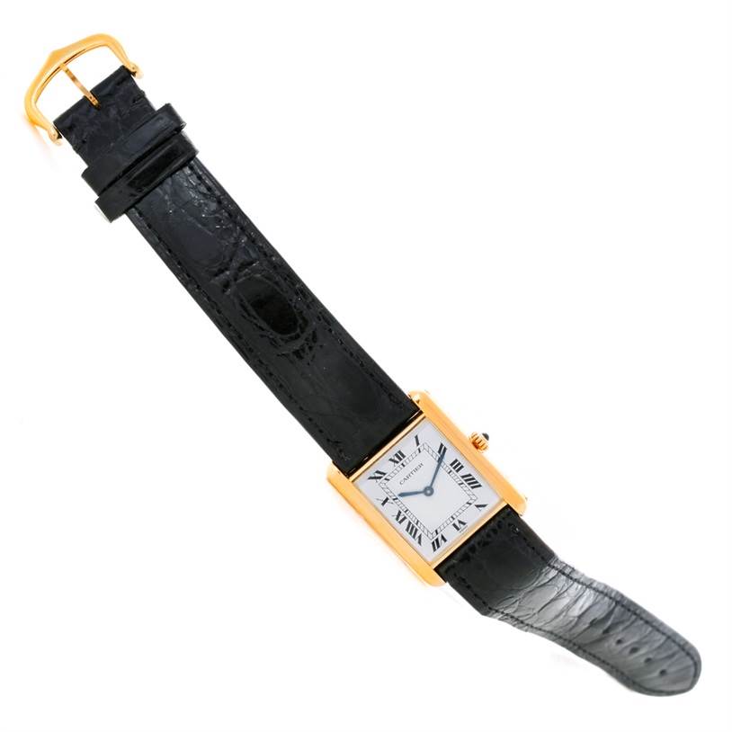 The image shows a top-down view of a Cartier Tank Classic Yellow Gold White Dial Yellow Gold White Dial watch with a black leather strap and gold-tone rectangular case.