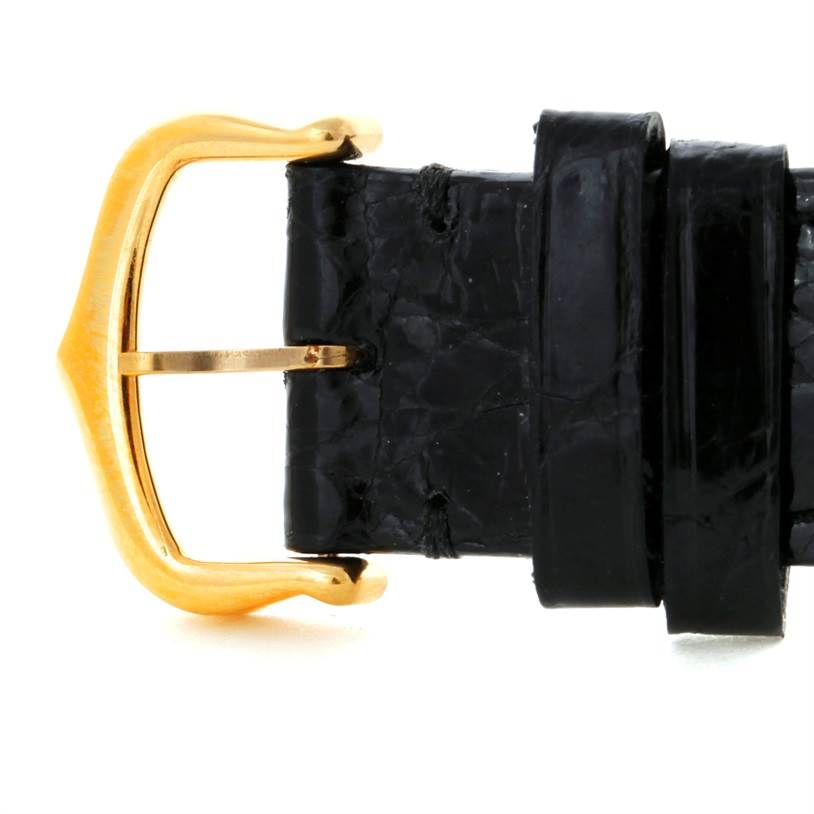 This image shows a close-up of the gold buckle and black leather strap of a Cartier Tank Classic Yellow Gold White Dial Yellow Gold White Dial watch.