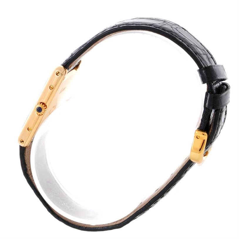 This image shows a Cartier Tank Classic Yellow Gold White Dial Yellow Gold White Dial model's side profile, featuring a gold case, black leather strap, and buckle.