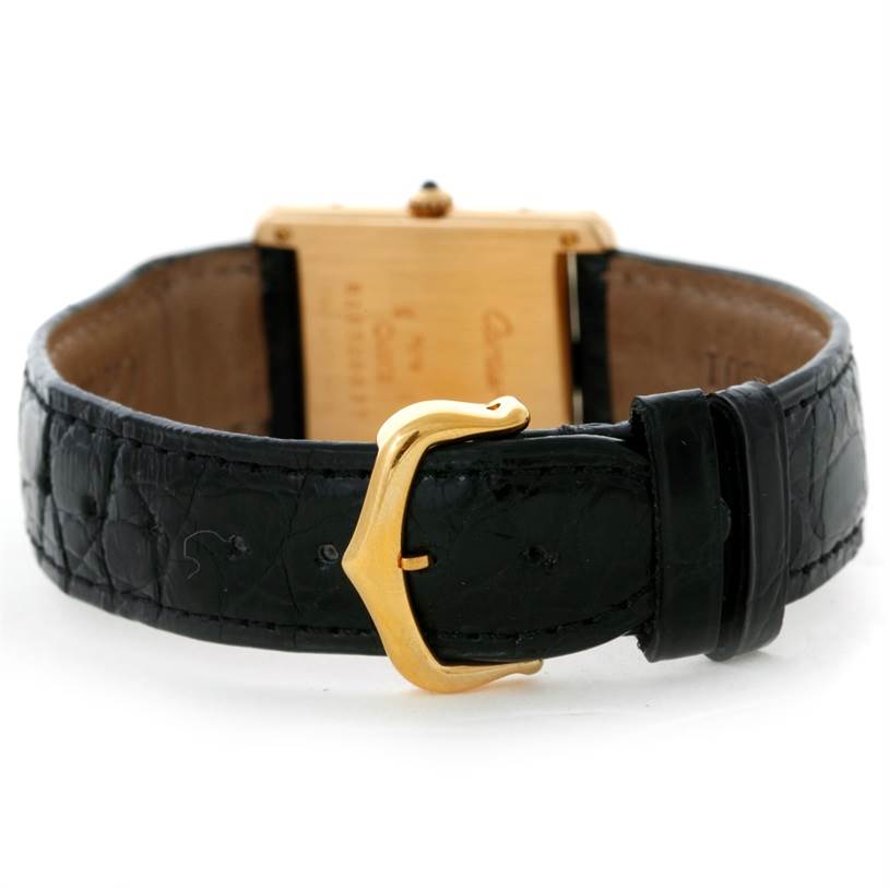 The image shows the back view of a Cartier Tank Classic Yellow Gold White Dial Yellow Gold White Dial watch, highlighting its black leather strap and gold buckle.