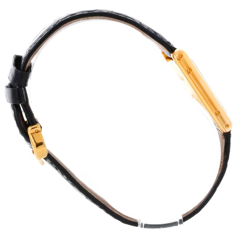 This image shows a side view of the Cartier Tank Classic Yellow Gold White Dial Yellow Gold White Dial watch, highlighting its gold case and black leather strap.